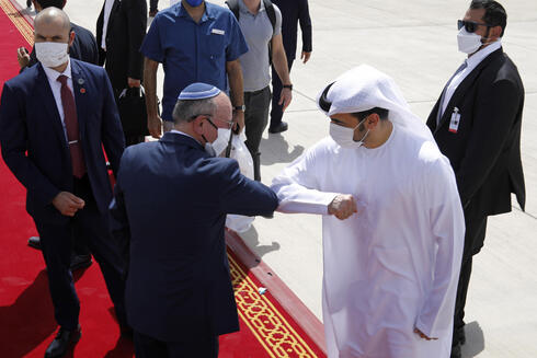     Israeli National Security Adviser Meir Ben-Shabbat bumps over Emirati official as he makes his way aboard the plane to leave Abu Dhabi
