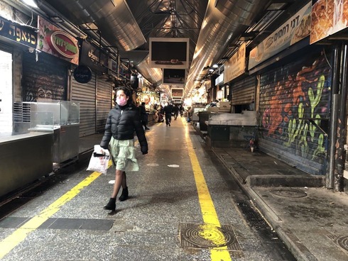 Woman walks through an abandoned Mahane Yehuda market in Jerusalem during COVID-19 pandemic (Photo: Gil Yochanan) שוק מחנה יהודה