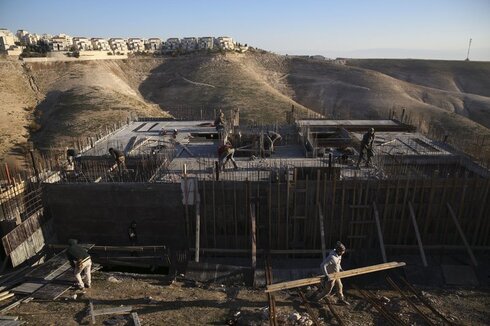 Palestinian workers work at a construction site in the city of Israel at Maale Adumim, near Jerusalem 