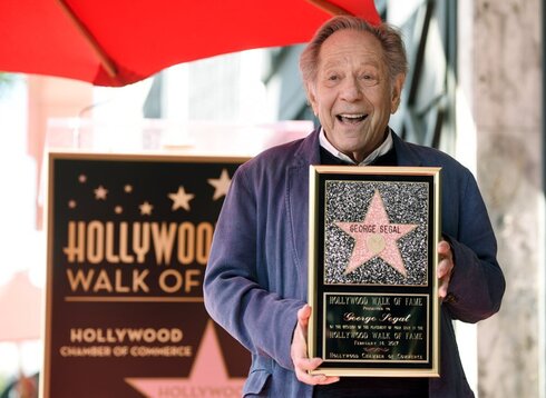 George Segal stands with a replica of his star at a ceremony honoring him on the Hollywood Walk of Fame in Los Angeles, February 2017 