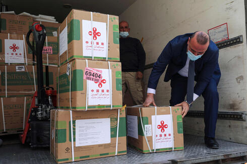 Palestinian Ministry of Health staff drop off a shipment of the Chinese government's Synopharm COVID-19 vaccines in the West Bank city of Ramallah 