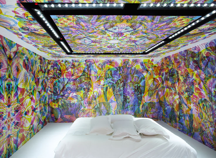 חדר אחר ב-dream box, שבמרכזו רק מיטה לבנה. הקסם הוא בקירות, שמחליפים צבעים וצורות בהתאם לתאורה המשתנה (צילום: Francis Amiand)