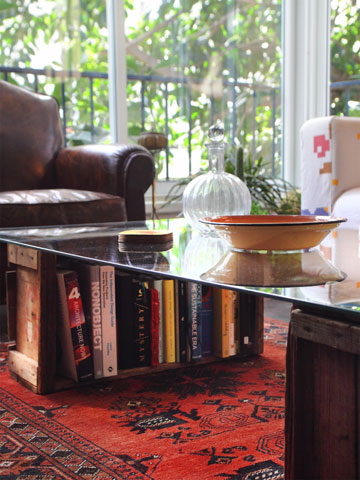 שולחן הקפה מורכב מפלטת זכוכית שהונחה על ארגזי פרי הדר (צילום: אמית הרמן)