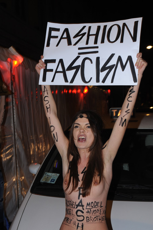 אופנה שווה פשיזם. מפגינה ללא חלק עליון נושאת שלט (צילום: ספלאש/א.ס.א.פ קריאייטיב)