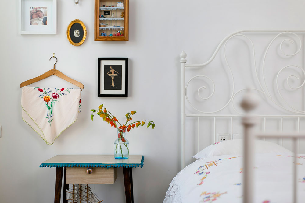 חדר השינה של ההורים. כיסוי המיטה הוא בן 70 שנה. גם הקישוטים שעל הקיר מבטאים את אהבתה של בעלת הבית לפריטים ישנים ולטקסטיל (צילום: שירן כרמל)