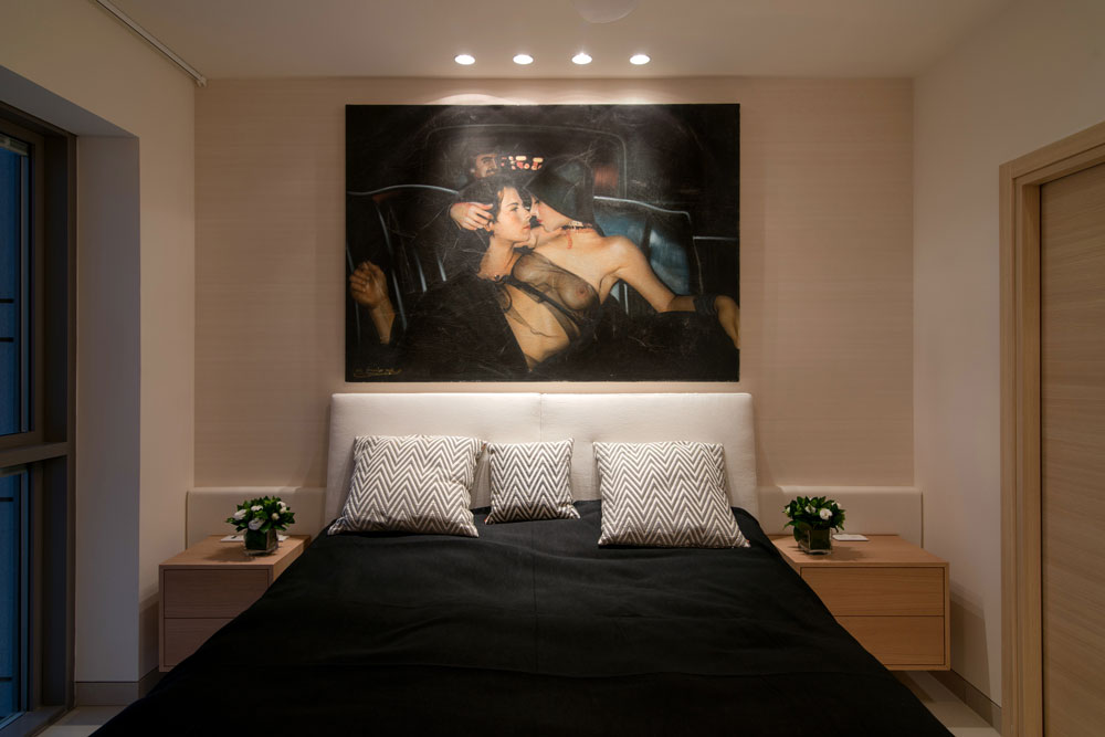 חדר השינה דרמטי, עם כיסוי מיטה שחור וצילום גדול שתלוי מעליה. בכלל, בדירות שהיא מעצבת יש חדרי שינה דרמטיים וגדולי ממדים, כפי שדירות יקרות יכולות להציע (צילום: אילן נחום)