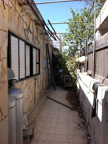 צד הבית, "לפני": הקיר חופה באבנים צהבהבות (באדיבות STUDIO IN2)