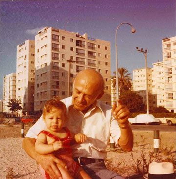 הכותב עם סבו על רקע בתי נוה אביבים (צילום: אוולין יעקובסון)