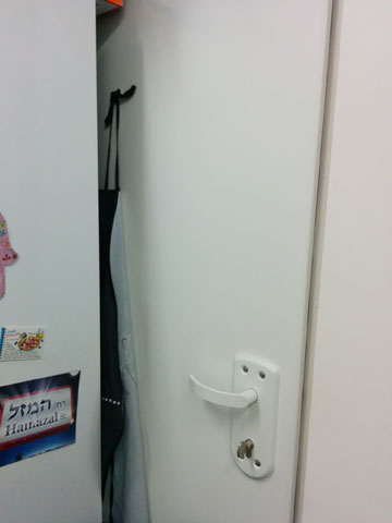 המקרר ש''שיכון ובינוי'' שמו במטבח בממ''ק חוסם את דלת היציאה לחדר המדרגות (צילום: אורין רוזנר)