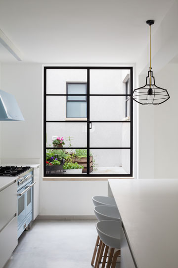 החלון במטבח פונה לפטיו ובו עציצי תבלין (צילום: טל ניסים)