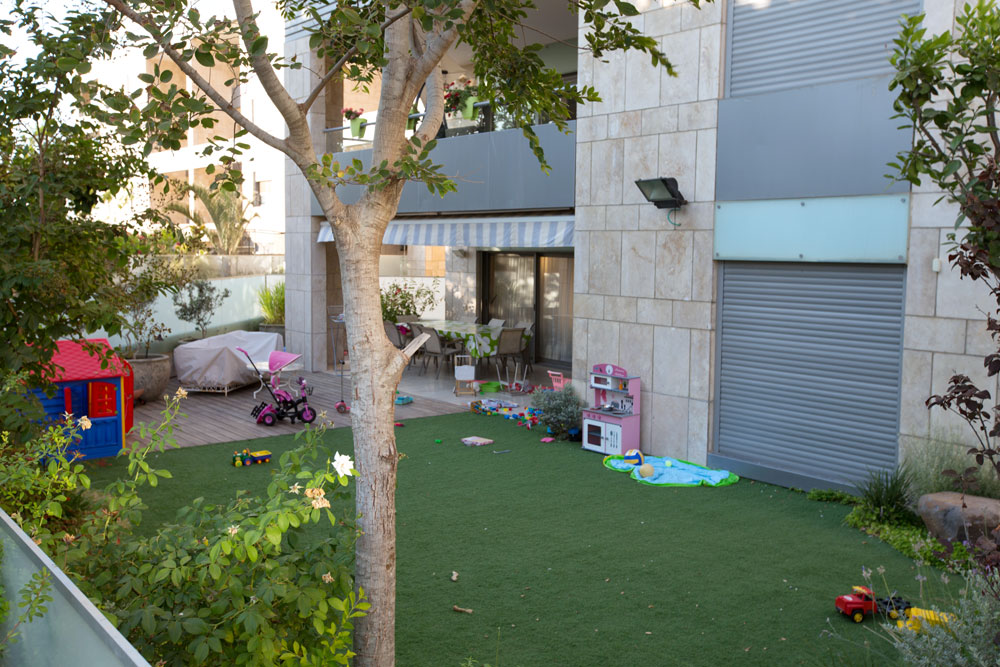 מרבד פלסטיק ירוק בגינת בניין בצפון תל אביב. יניב להב מ''להב פיתוח ונוי'', אחד המתקינים הגדולים בדרום, מספר כי רק שני לקוחות מתוך כ-30 גינות חדשות שהוזמנו השנה ביקש דשא אמיתי (צילום: דור נבו)