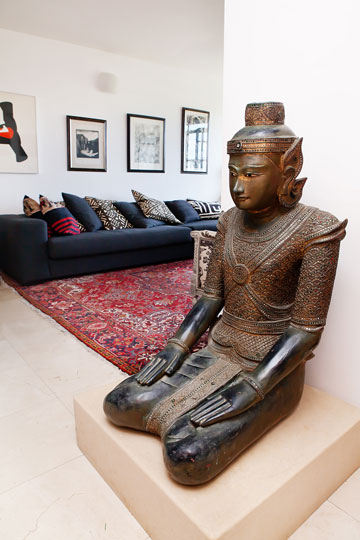 בובת בודהה גדולה וכלי מוזיקה מאפריקה בסלון (צילום: ענבל מרמרי)