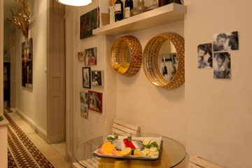 מבט מהמטבח אל המסדרון. Reggiano Mirror , המראות של אביעד משאלי, מתפקדות כמדף ללימונים (צילום: גדעון לוין )