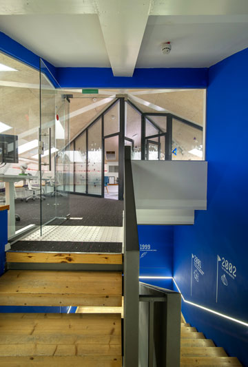 חדר המדרגות נצבע בכחול, עם ציר זמן שמסמן אבני דרך של החברה (צילום: אילן נחום)