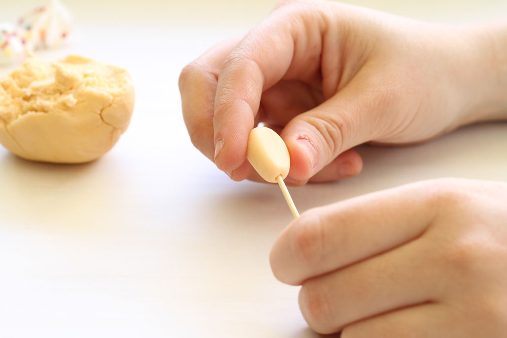 7. יוצרים מבצק סוכר לבן שתי צורות ביצים קטנות, משטחים אותן ומשפדים מצדן הצר - אלה יהיו הידיים (צילום: מיכל אורן)