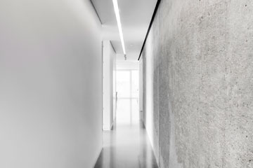 קיר הבטון במסדרון הארוך קולף ממעטה הגבס וסותת בעבודת יד עד שהושגה התוצאה החומרית הרצויה (צילום: Richard Jochum)
