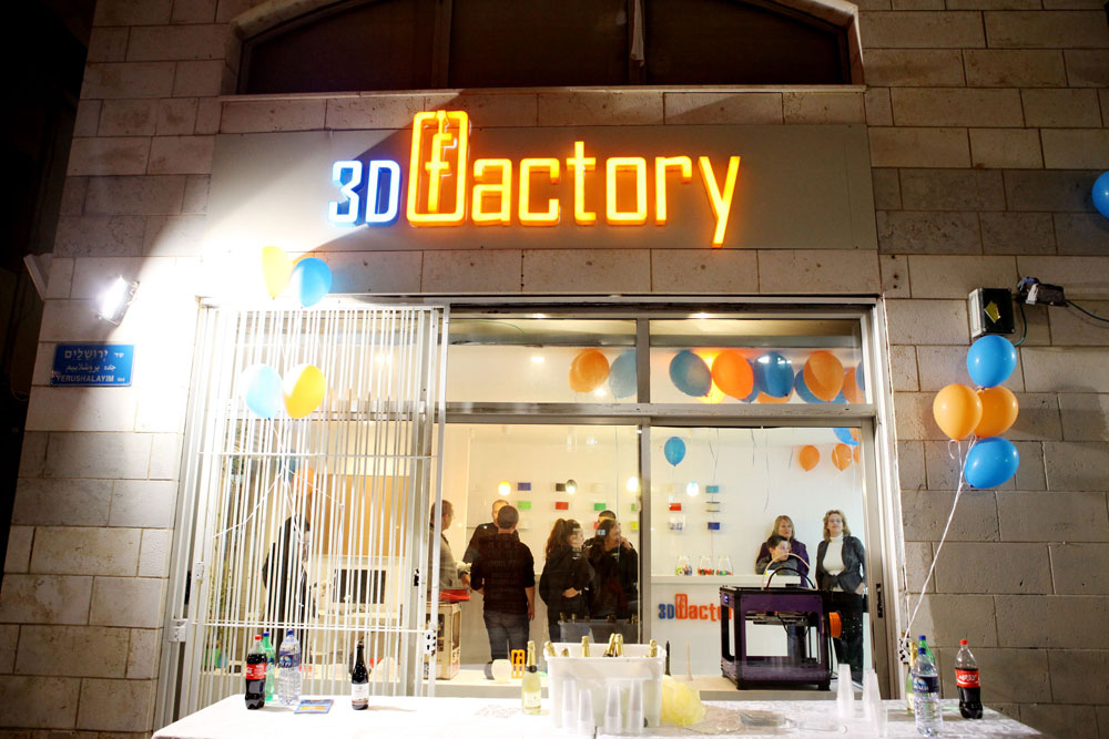 פתיחת החנות ''3D Factory'' בשכונת נגה ביפו, במוצאי שבת האחרונה. כבר בשבועות שקדמו לפתיחה עמדו עוברי אורח מול החלון והסתכלו בתהליך הדפסת המוצרים, מרותקים מהחידוש (צילום: אורית פניני)