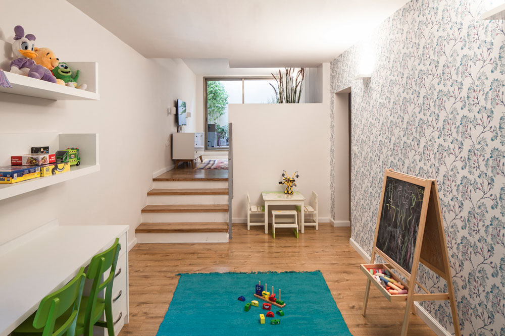 מפינת המשפחה יש ירידה לחדר המשחקים של הילדים, בצבעים עליזים של ירוק, טורקיז וסגול (צילום: עמית גרון)