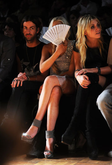 לינדזי לוהן מתחבאת מאחורי המניפה בתצוגת האופנה של פיליפ פליין (צילום: gettyimages)