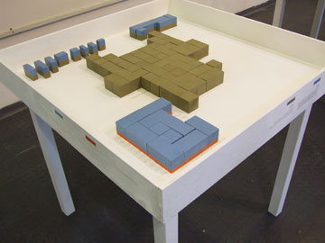 מתוך המיצג של עמית סקל: כל שולחן מציג מבנה קיבוצי (צילום: תום מארשק)
