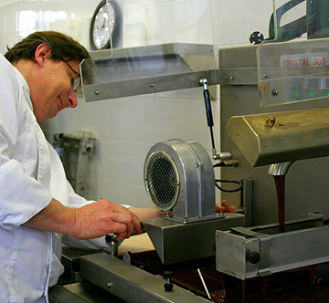 ז'נין מפשיל שרוולים ומתקן את מכונת הטמפרינג (צילום: שרון היינריך)