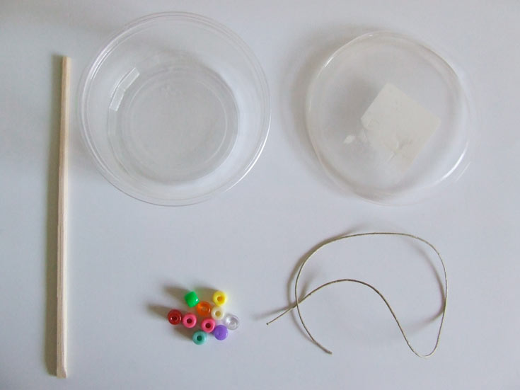החומרים הדרושים: קופסת פלסטיק, צ'ופסטיק אחד, חרוזים וחוט (באדיבות אתר 'את זה')