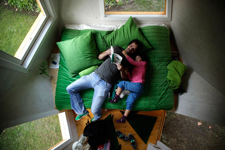 מיטת-ספה רחבה תופסת כמעט מחצית מהחדר, ולצידה יש שירותים עם כיור (צילום: Studio dass)