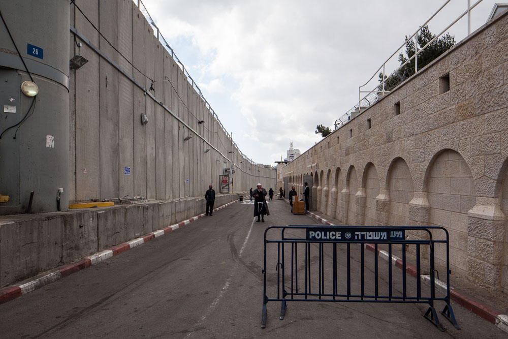 הקבר מימין, החומה משמאל. דרך בית לחם הפכה לרחבת גישה מכווצת. המבקרים מזדרזים לצאת מרכבם הפרטי או לרדת מהאוטובוס, ולהיבלע מאחורי חומות וקירות בטון. זו החוויה הרוחנית שממתינה להם, והיא לא הייתה כזו פעם קבר רחל