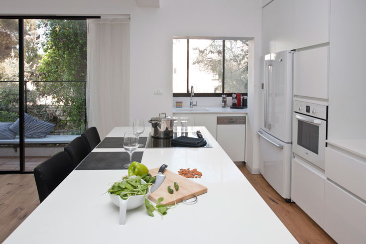 הצבע הלבן שולט בקירות ופריטי הנגרות והמסגרות. במטבח קיר ארונות לבן עם מקרר ותנור אפייה לבנים, וגם אי העבודה הגדול לבן. הכיור חבוי מעט, במה שהיתה מרפסת שירות דירה ברחביה זרקא אדריכלים