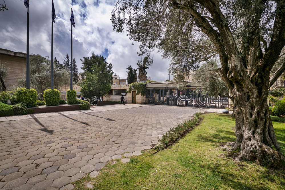 נכנסים דרך שער הברזל שעיצב בצלאל שץ, וחולפים על פני גן וו בריכת נוי, כותרות עמודים עתיקים ואבן ענקית מהר הבית, ויצירות אמנות נוספות של אגם וקדישמן בית הנשיא