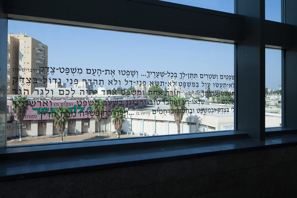 פסוקים מהמקורות על החלונות. עיצוב האולמות פשוט, סקאלת הצבעים בהירה ונעשה שימוש בגבס ובעץ מייפל בית המשפט המחוזי לוד