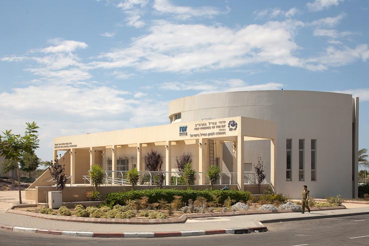 בית הכנסת החדש במחנה רעים, הסמוך לגבול עם רצועת עזה. צבעים רכים המשתלבים עם הנוף המדברי, ועצים שניטעו בכיכר שבחזית, כדי שתהפוך למוצלת ונעימה ותתפקד כחלל ביניים בין המחנה למרחב הקדוש בית כנסת בית הכנסת במחנה רעים מחנה רעים
